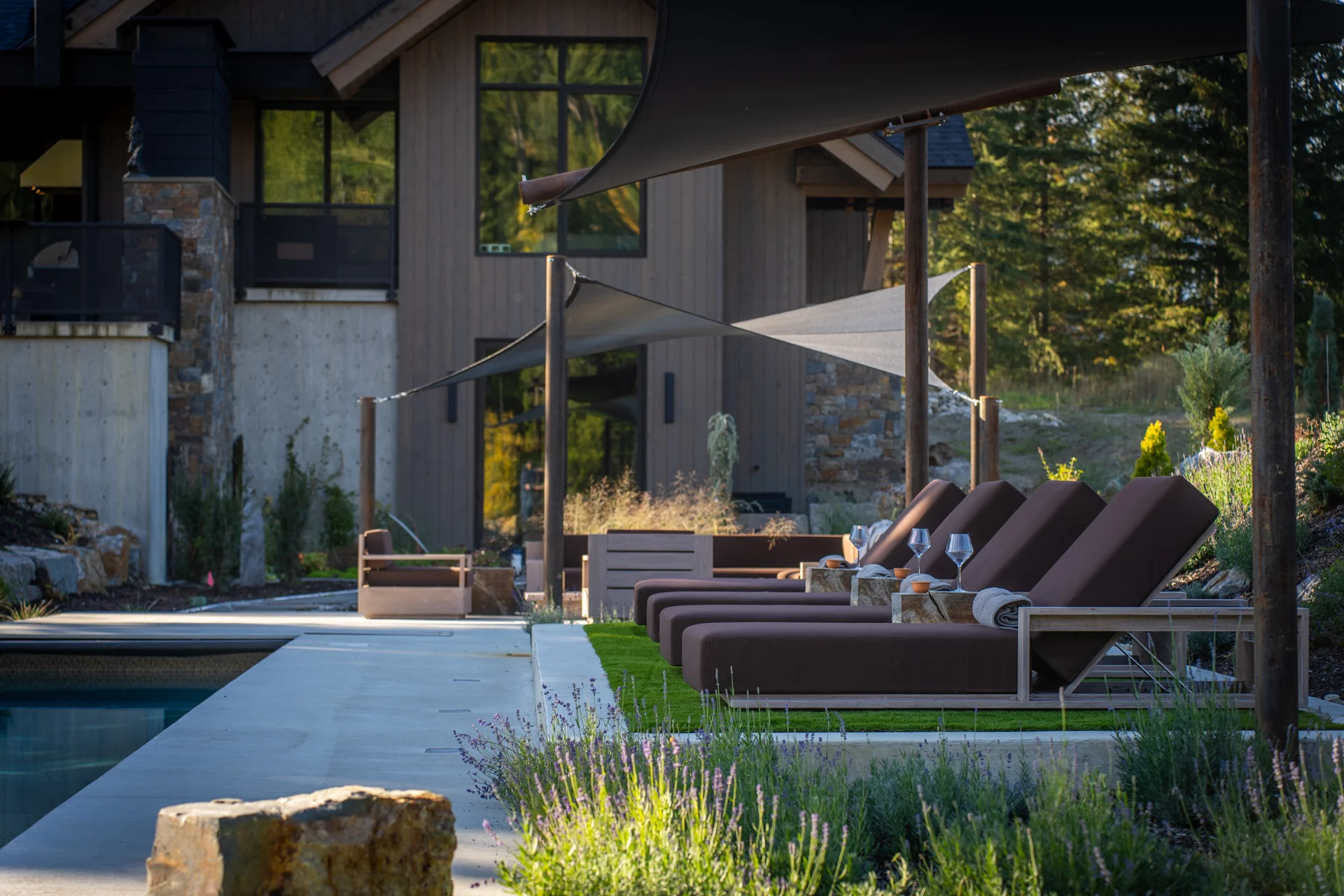 The elevated shaded lounge beneath the shade sail, beside the pool